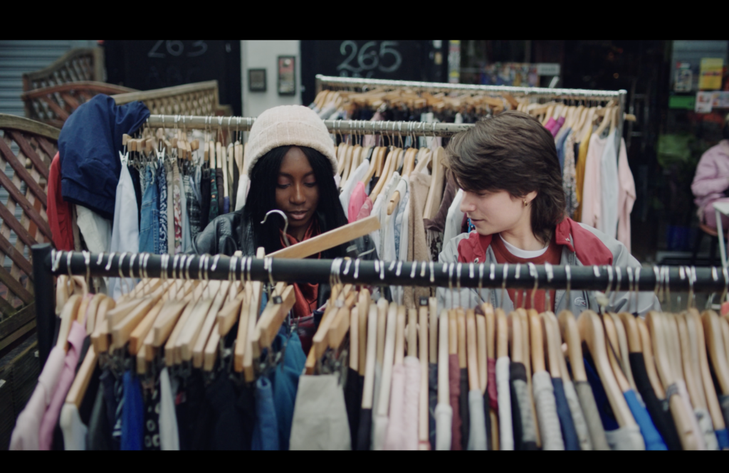 Two young people looking at clothes in a clothes shop