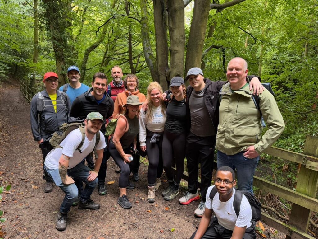 A number of people in a forest-y area in hiking clothes