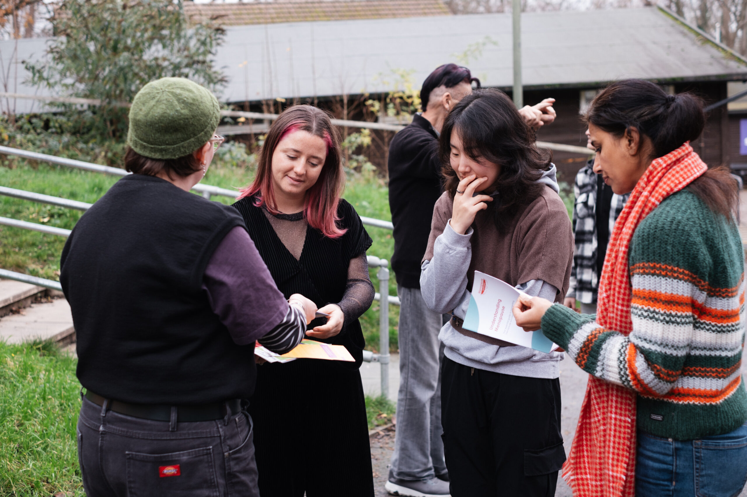 A number of people outdoors looking at Spectra flyers.
